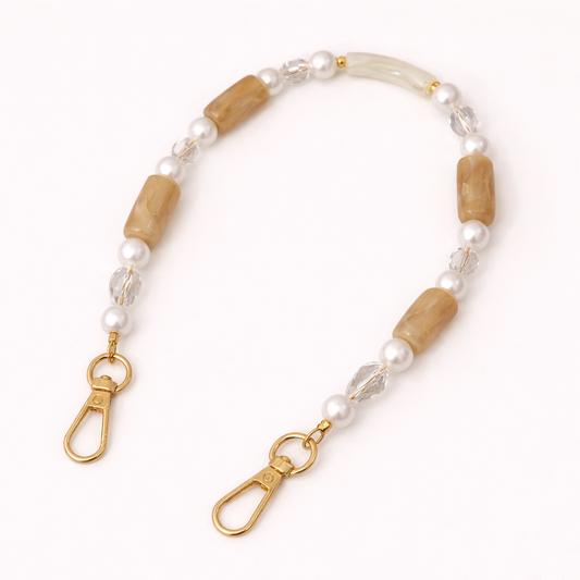 Tan beaded Loreto short phone strap coiled flat, finished with pearl, crystal, and gold-tone clasps.