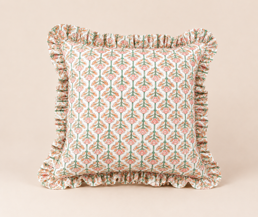 Front view of the Lotus Pink Square cushion with a pink and green floral block-print pattern and a soft ruffled edge on a beige background.