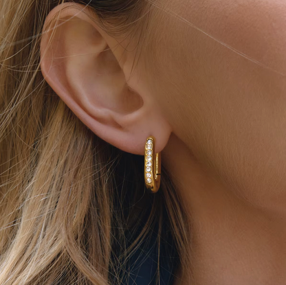Worn on a model's ear, the Love Bite EARRINGS show their pave crystal-lined rectangular hoop shape up close.