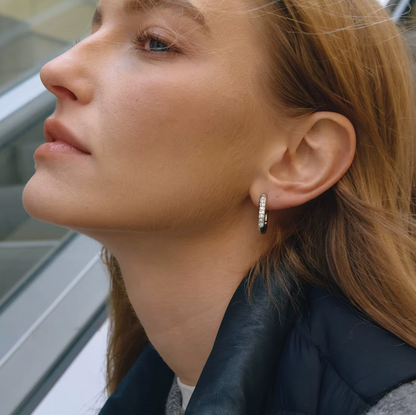 Worn on a model's ear, the silver Love Bite EARRINGS catch the light along their pave crystal edge nicely.