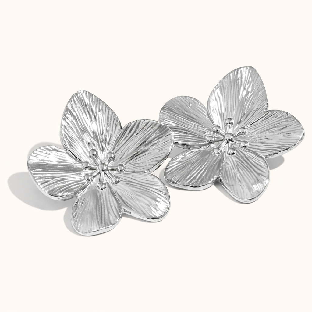 Love Language Earrings appear here in polished silver, their large textured flower petals catching the light.