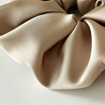 Lucia SCRUNCHIE XL close-up of the taupe satin fabric folds, texture detail shot.
