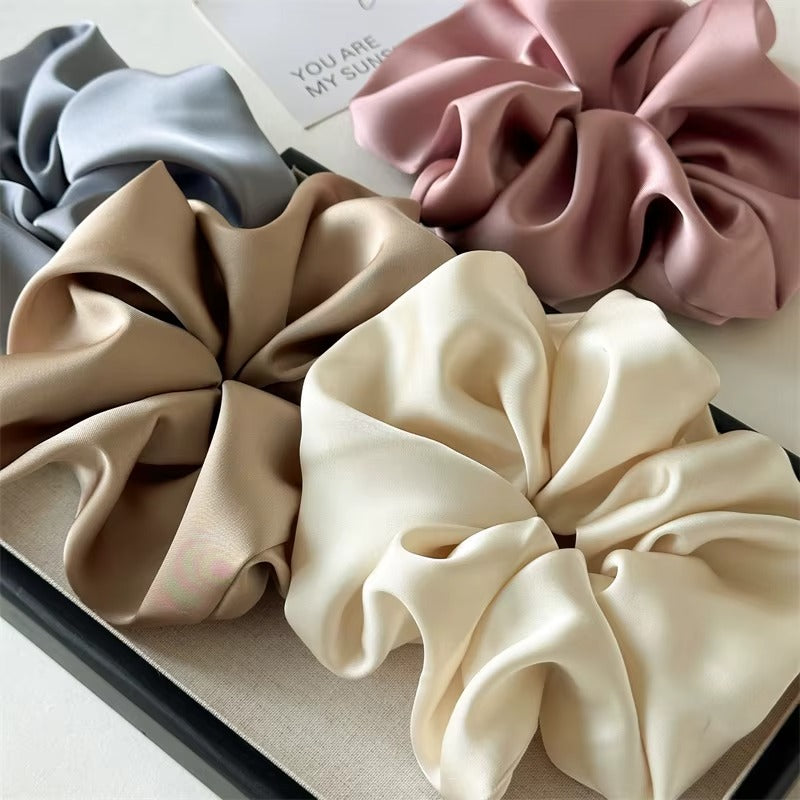Lucia SCRUNCHIE XL flat-lay of four colors in a gift box: grey, taupe, cream and mauve, with a greeting card.