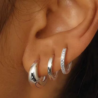 Close-up of the Lulu Set worn on the ear in silver tone, showing the teardrop, pave, and plain hoops stacked.