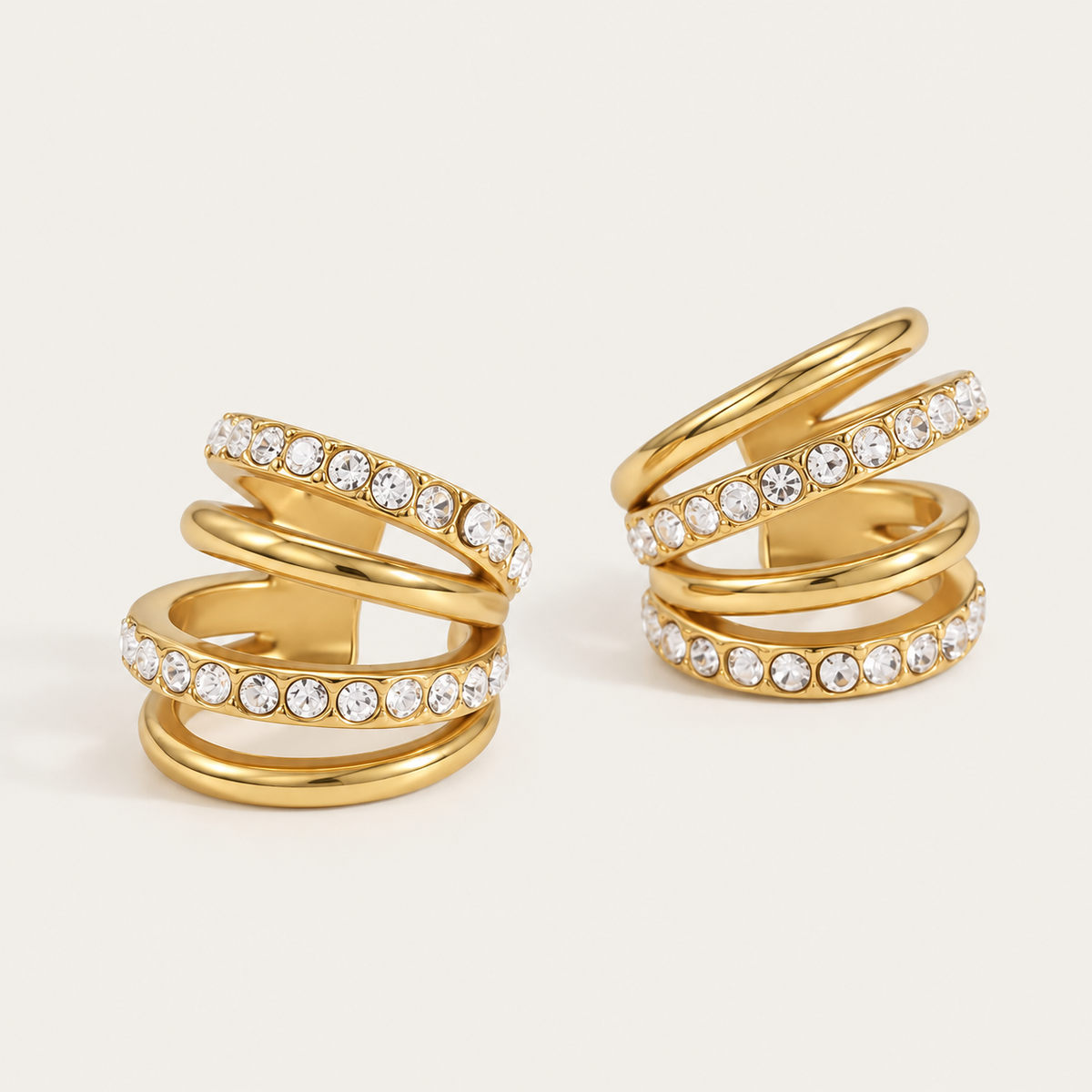 Pair of gold ear cuffs with a triple-row pavé crystal wrap, product shot for the Folie à Trois Lumen EAR CUFF.