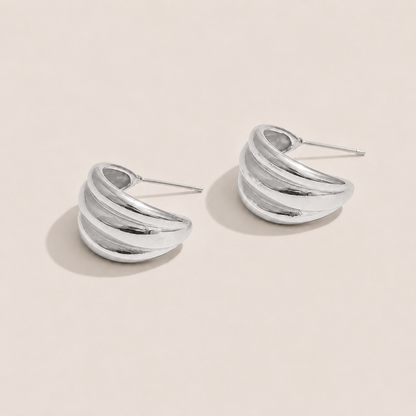 Silver ridged half-hoop earrings with a chunky ribbed texture on a cream backdrop — Folie à Trois Lustro EARRINGS