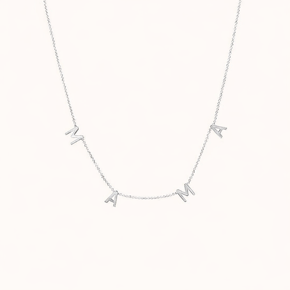 The Mama NECKLACE in silver, individual letters spelling MAMA dangling from a fine chain, shown on a cream background.