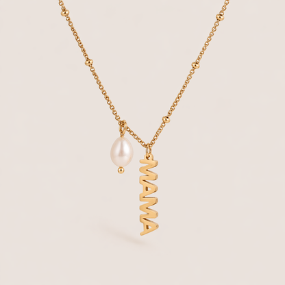 The Mama Pearl NECKLACE laid flat, showing a gold satellite chain with a dangling freshwater pearl beside a vertical MAMA script charm.