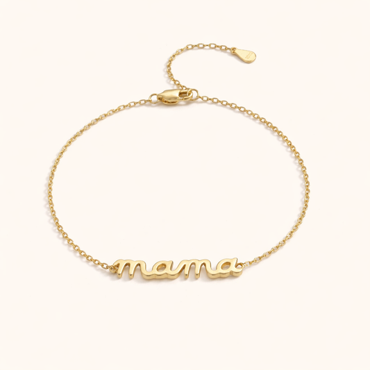 Mama Small BRACELET gold chain bracelet with a small cursive mama script charm, studio flat-lay on cream.