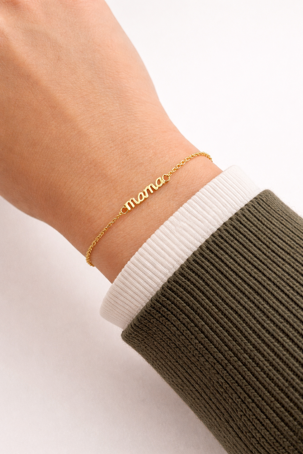 Mama Small BRACELET worn on the wrist, close-up of the cursive mama charm with a white and olive sleeve.