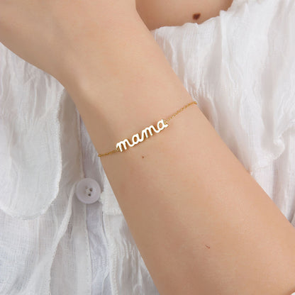 Mama Small BRACELET worn on the wrist with the cursive mama charm, model in a white ruffled top.