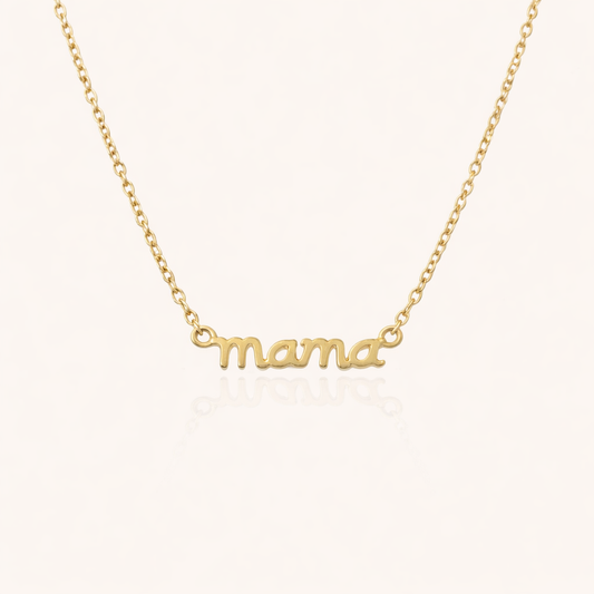 The Mama Small NECKLACE in gold, a delicate script mama pendant on a fine chain, shown flat on a cream background.