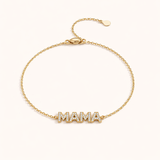 Mama Zirconia BRACELET gold chain bracelet with a pave crystal MAMA charm, studio flat-lay on cream.