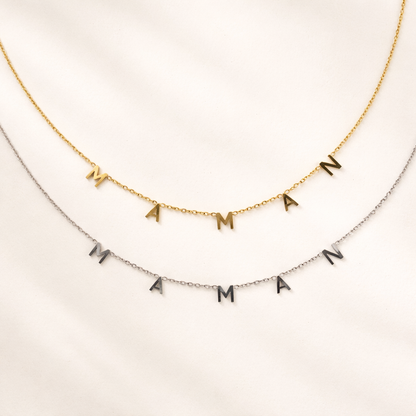 The Maman NECKLACE in gold and silver, individual letters spelling MAMAN dangling from two layered fine chains.