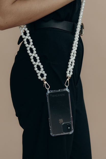 Model in black holding a phone in a clear case suspended from the Folie à Trois Marnie Pearl wholesale phone chain, worn crossbody.