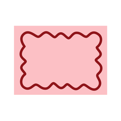 Overhead view of a pink Maude wave-trim placemat styled with grapefruit halves, a coffee mug, milk and fresh bread.