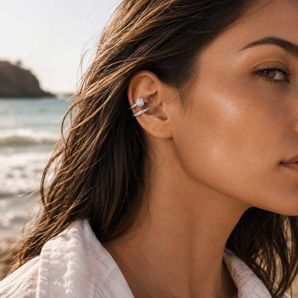 The Maya EAR CUFF in silver worn on the ear cartilage, the double-band cuff with its round gem shown at the beach.
