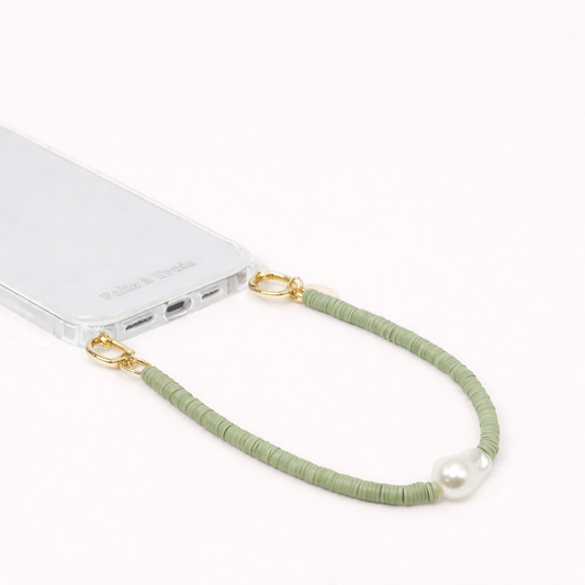Green heishi bead Melody SHORT PHONE CORD with a baroque pearl accent, clipped to a clear phone case.