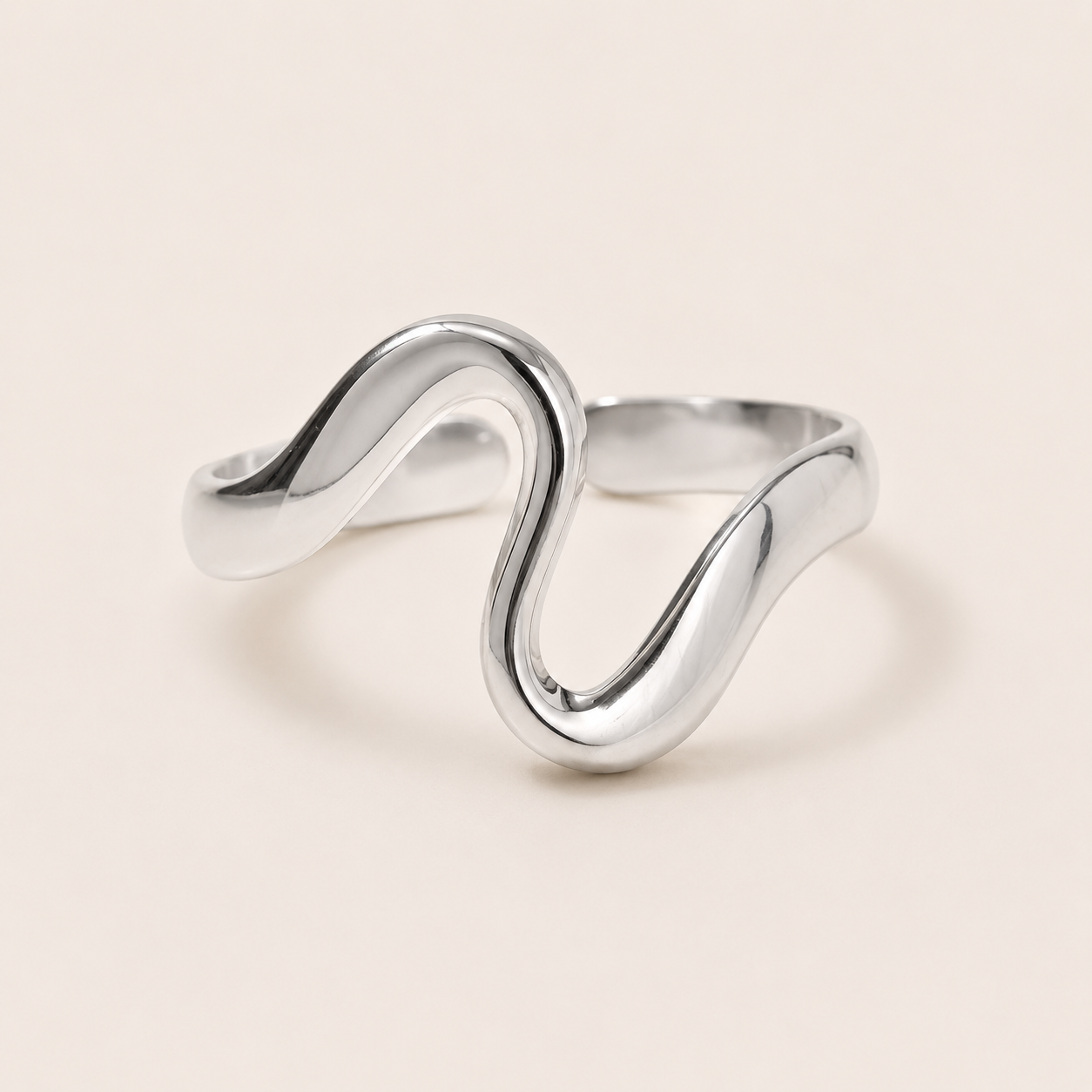 Silver open ring with a fluid S-curve wave design, shown in close-up on a cream backdrop — Folie à Trois Menton RING.