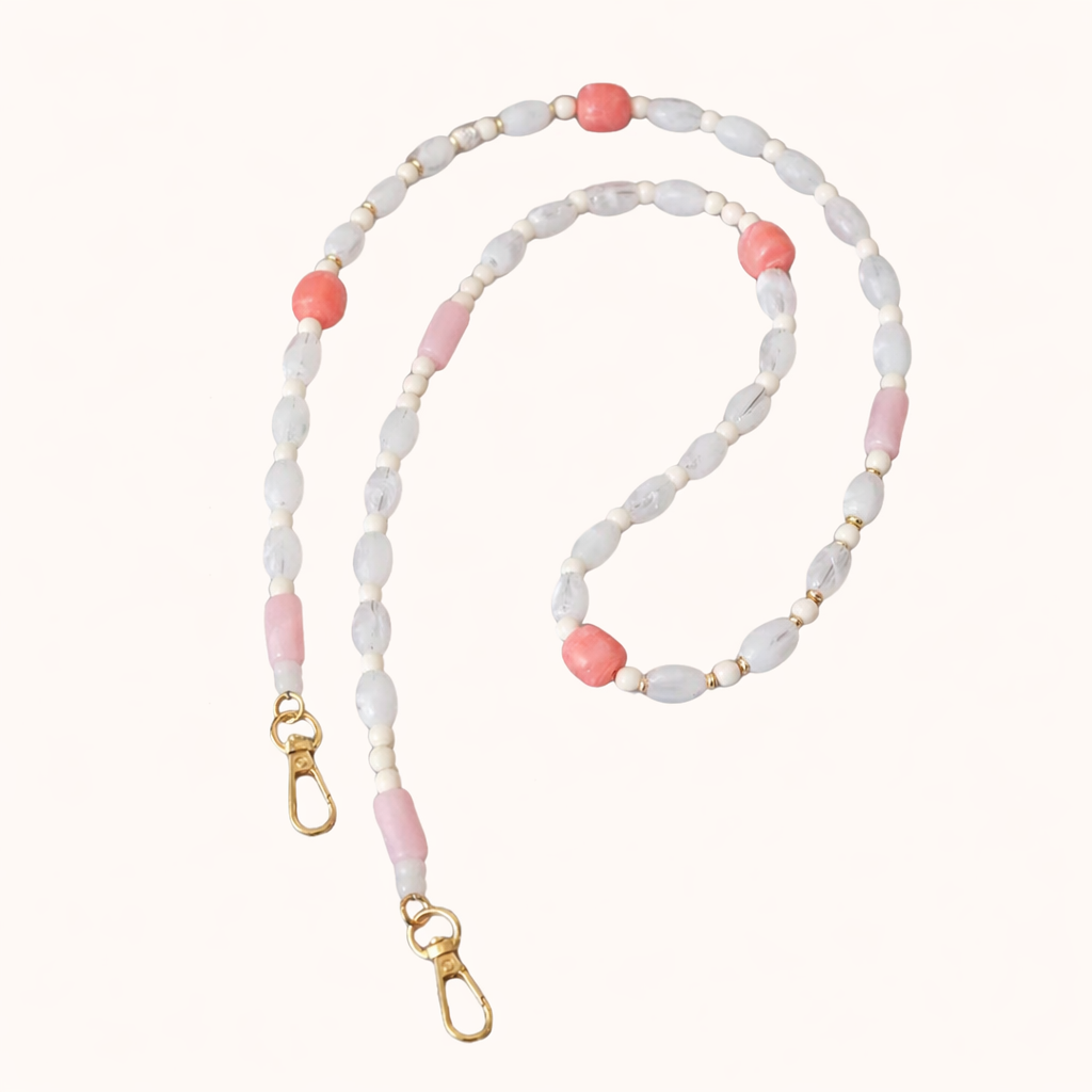 White and coral beaded Meryn long phone chain coiled flat with gold-tone clasp ends.
