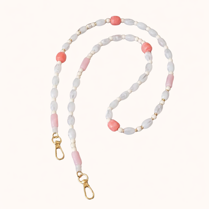 White and coral beaded Meryn long phone chain coiled flat with gold-tone clasp ends.