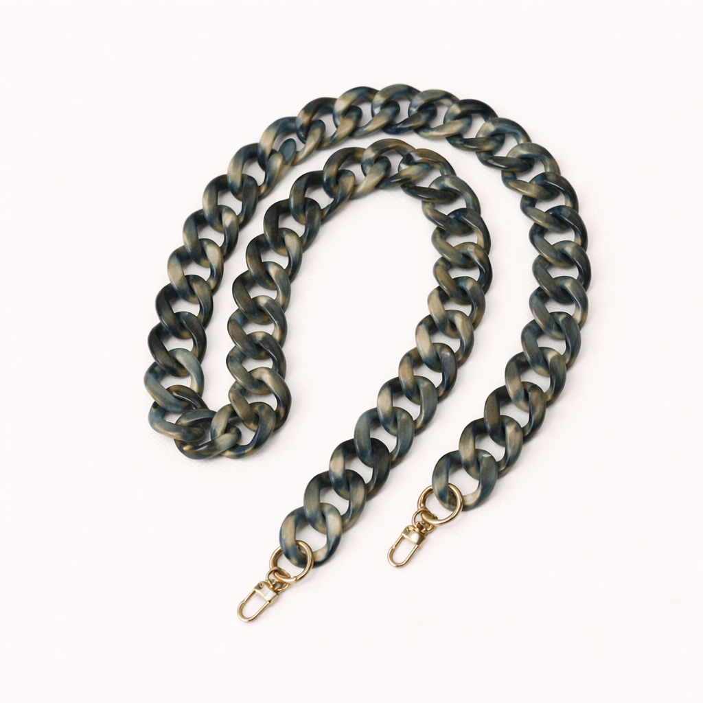 A coiled blue-grey and gold marbled acrylic curb-link phone chain with gold clasps, shown on a cream background.