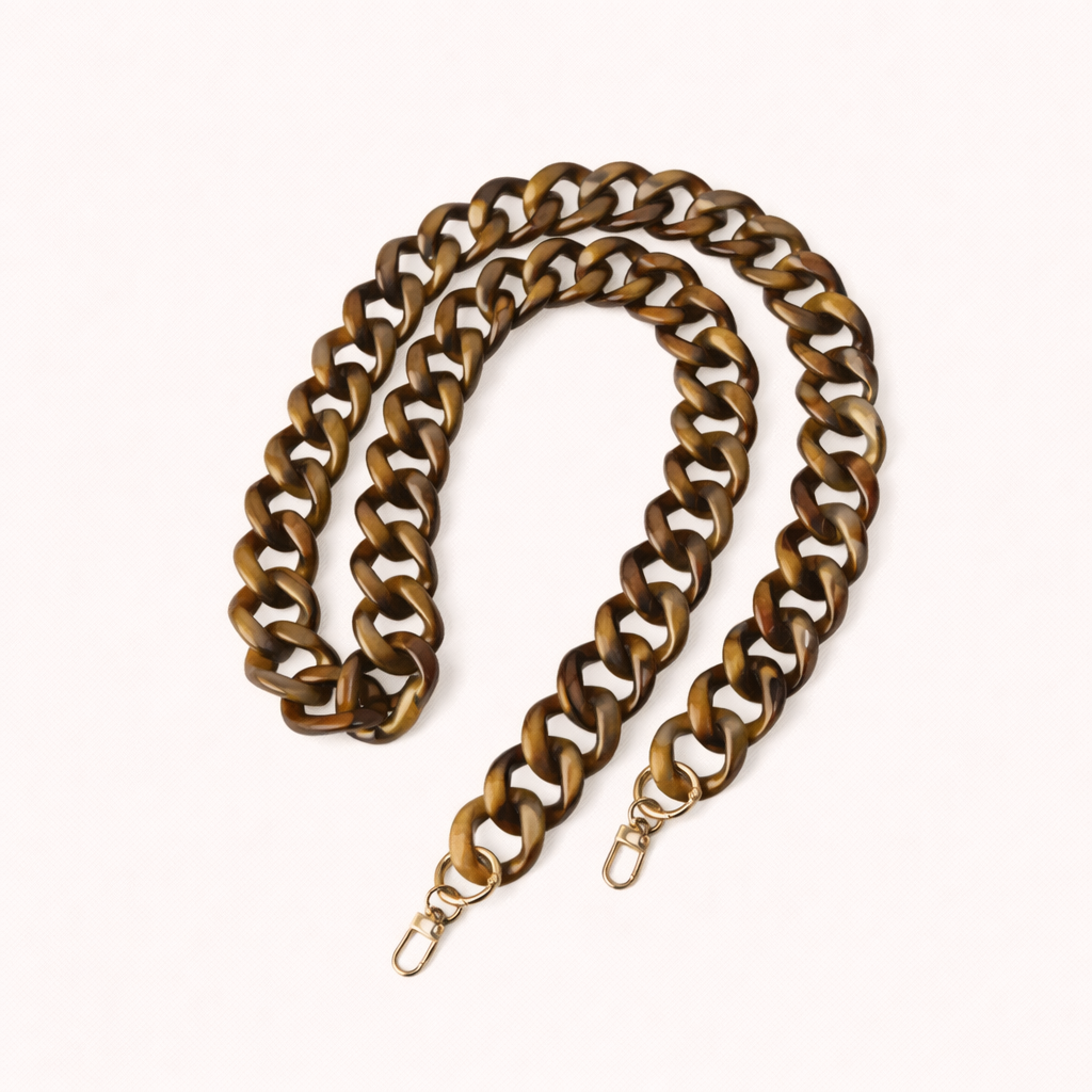 A coiled bronze and brown marbled acrylic curb-link phone chain with gold clasps, shown on a cream background.
