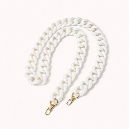 A coiled solid white acrylic curb-link phone chain with gold clasps, shown on a cream background.