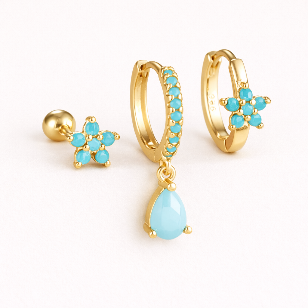 The Mica SET is shown in a soft turquoise colorway across its flower stud, drop hoop, and flower huggie.