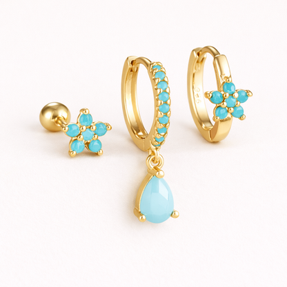 The Mica SET is shown in a soft turquoise colorway across its flower stud, drop hoop, and flower huggie.