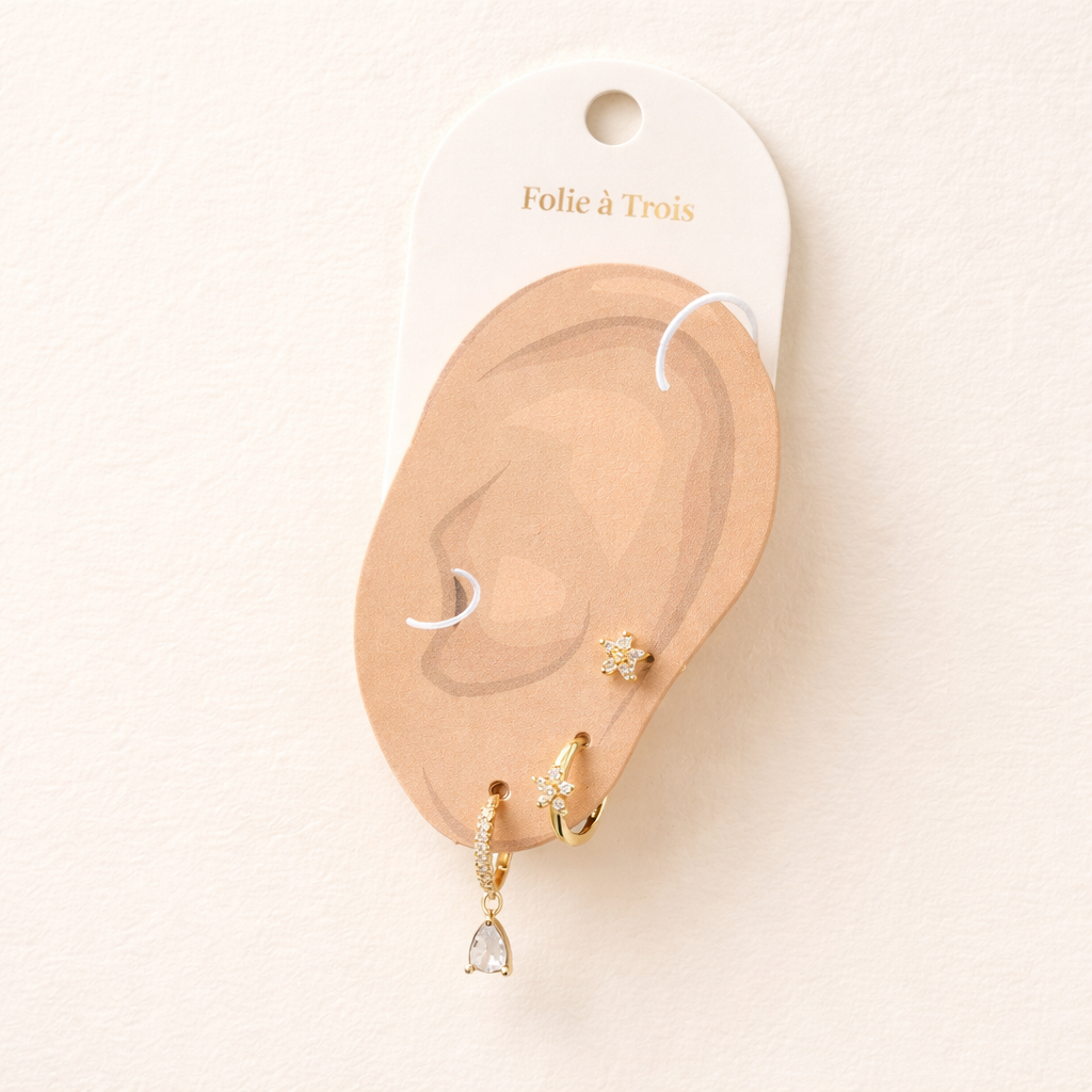 The Mica SET is displayed on a branded card shaped like an ear, showing all three gold pieces in place.