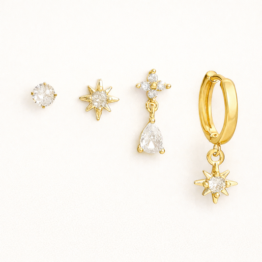 Mila Set of four gold pieces: a round solitaire stud, a star stud, a pear-crystal drop, and a star-charm huggie hoop.