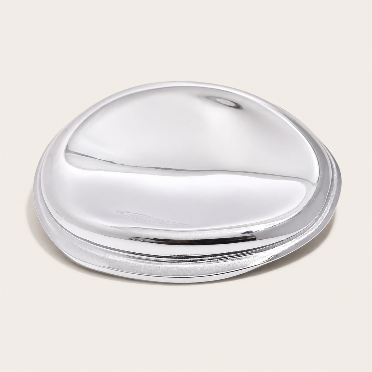 Silver molten pebble-shaped brooch with a glossy, sculptural finish on a cream backdrop — Folie à Trois Mina BROOCH.