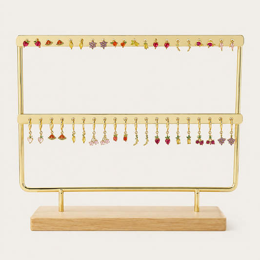 The Mini Folie 20-pieces BUNDLE on a gold stand, showing an assortment of fruit and charm stud earrings paired with matching dangle hoops.