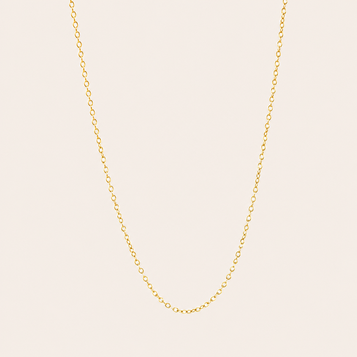 The Minimal NECKLACE in a flat lay, a fine gold cable chain shown plain with no charms on a cream background.