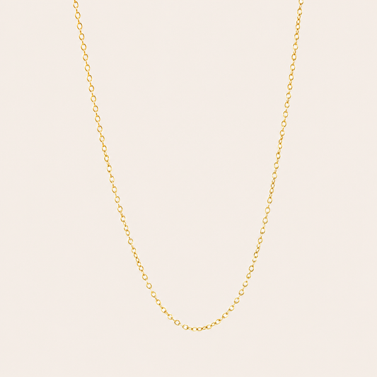 The Minimal NECKLACE in a flat lay, a fine gold cable chain shown plain with no charms on a cream background.