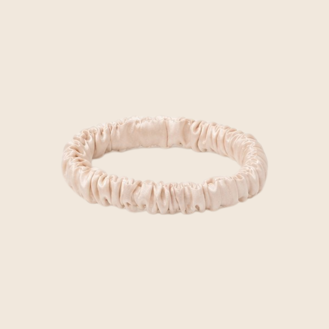 Minnie SCRUNCHIE S small satin scrunchie in cream, studio shot on a light beige background.