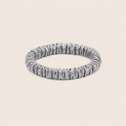 Minnie SCRUNCHIE S small satin scrunchie in silver, studio shot on a light beige background.