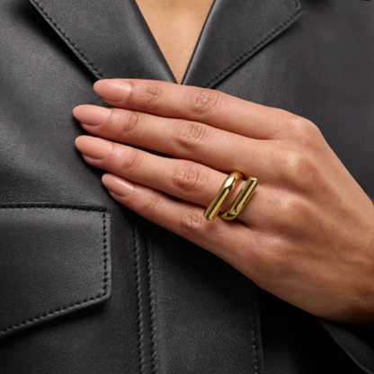 Model wears the gold Mischa RING with its parallel-bar design, hand resting on her leather jacket.