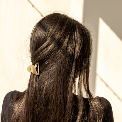 Mon Cœur HAIR CLIP in cream, worn holding a half-up style on dark hair, back view in sunlight.