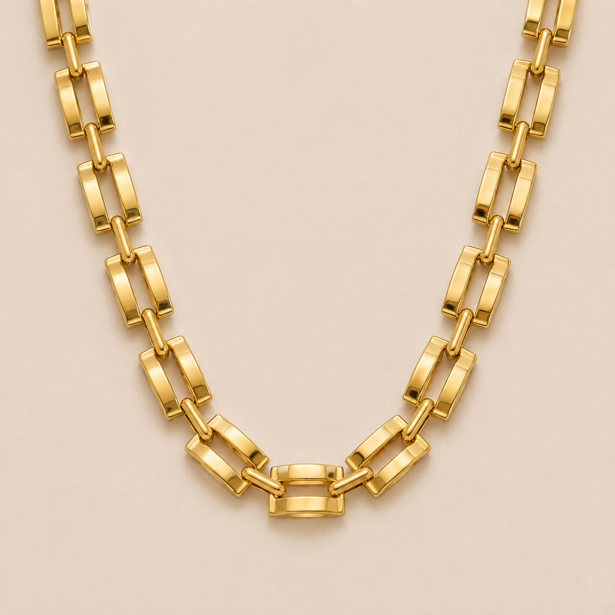 Gold flat rectangular-link chain necklace, the Mona NECKLACE, featuring bold panther-style links in a close-up studio shot.