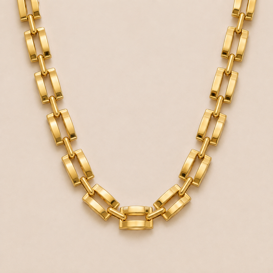 Gold flat rectangular-link chain necklace, the Mona NECKLACE, featuring bold panther-style links in a close-up studio shot.