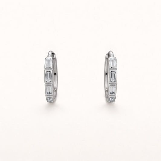 Monday To Friday Earrings set a row of alternating baguette-cut clear stones into a polished silver hoop.