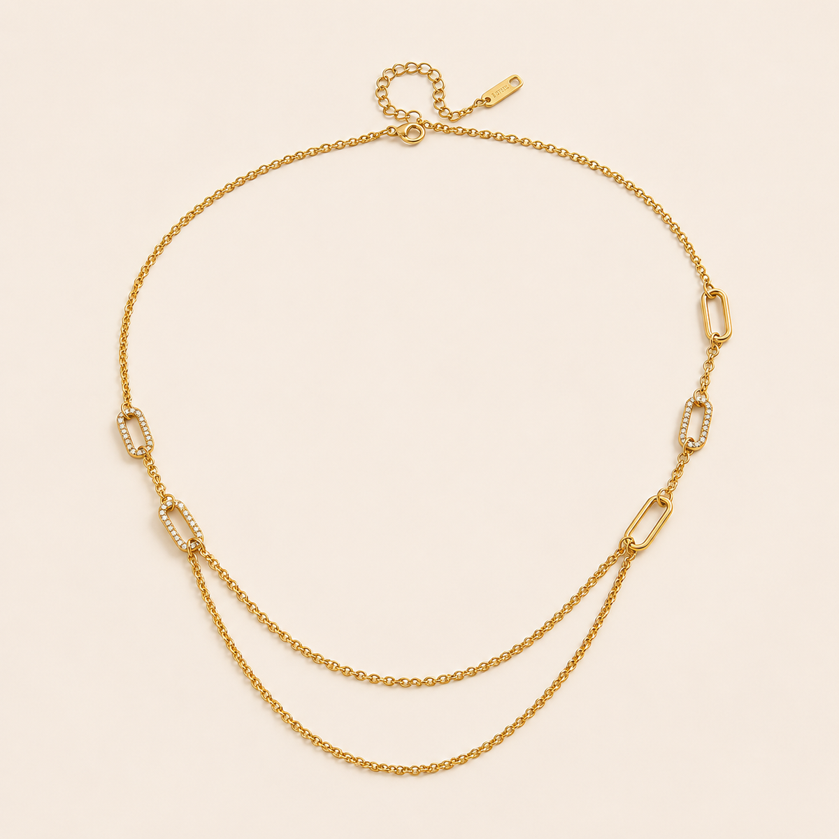 The Mora NECKLACE laid flat, showing pave crystal paperclip links alternating with plain cable chain and a draped double-chain section.