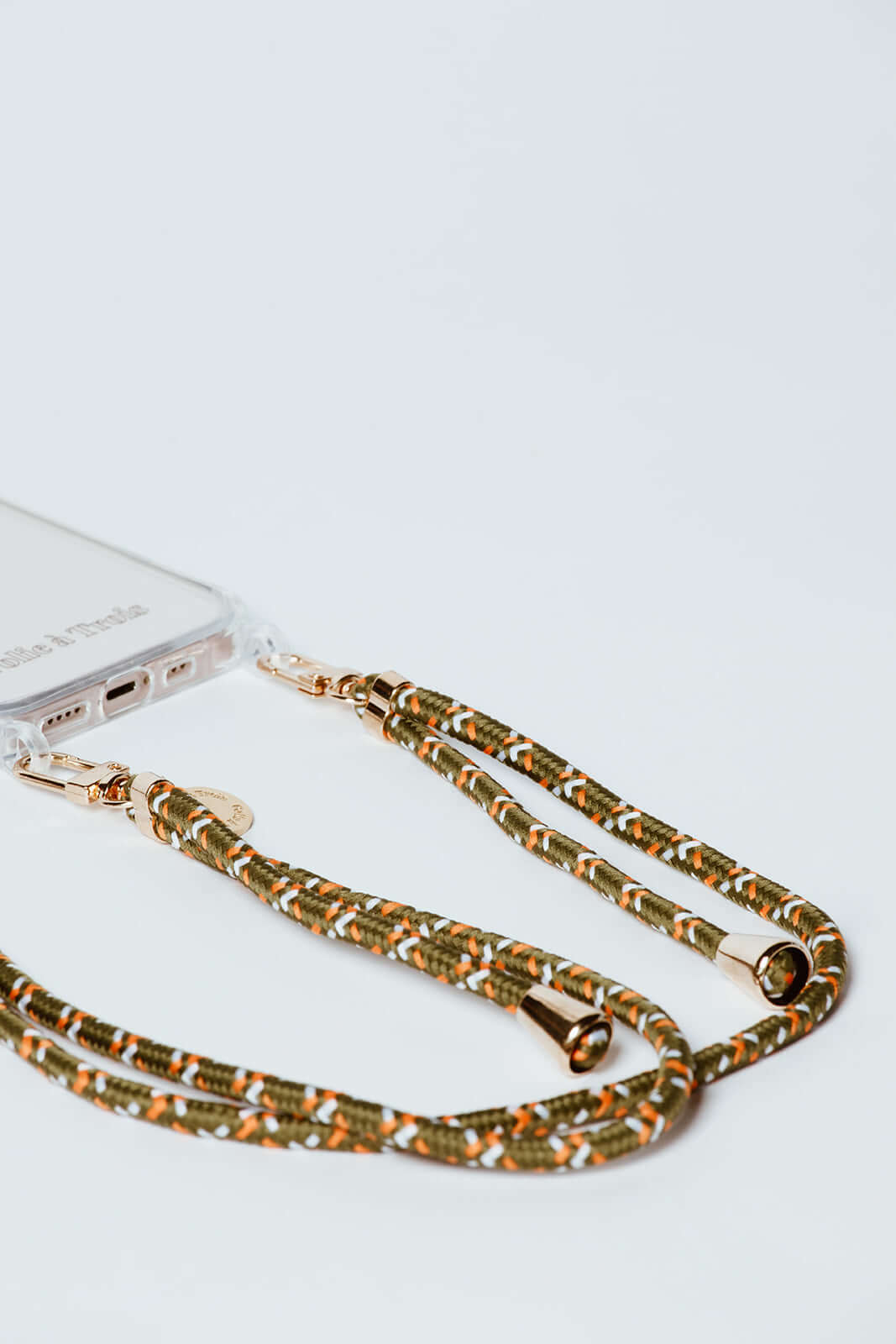 Olive, orange and white woven Multi Colorful PHONE CORD attached to a clear phone case, close-up on white.