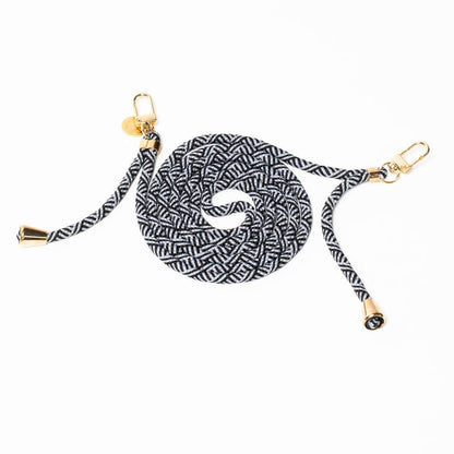 Black and white patterned Multi Colorful PHONE CORD coiled with gold-tone hardware on a white background.