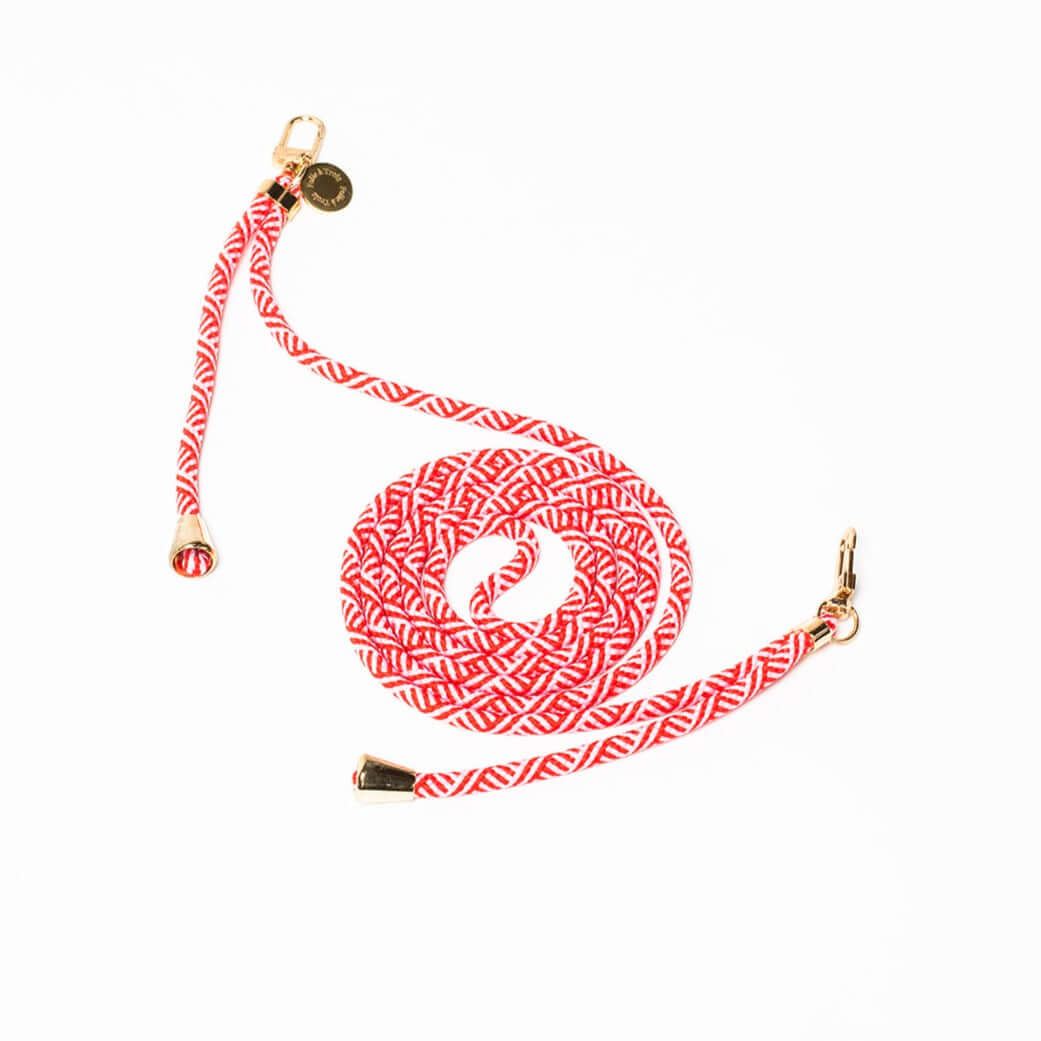 Red and white patterned Multi Colorful PHONE CORD coiled with gold-tone hardware on a white background.