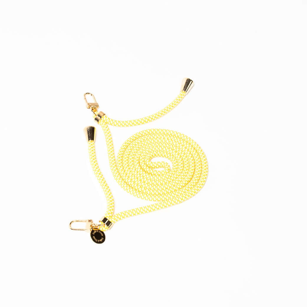 Pale yellow and white patterned Multi Colorful PHONE CORD coiled with gold-tone hardware on white.