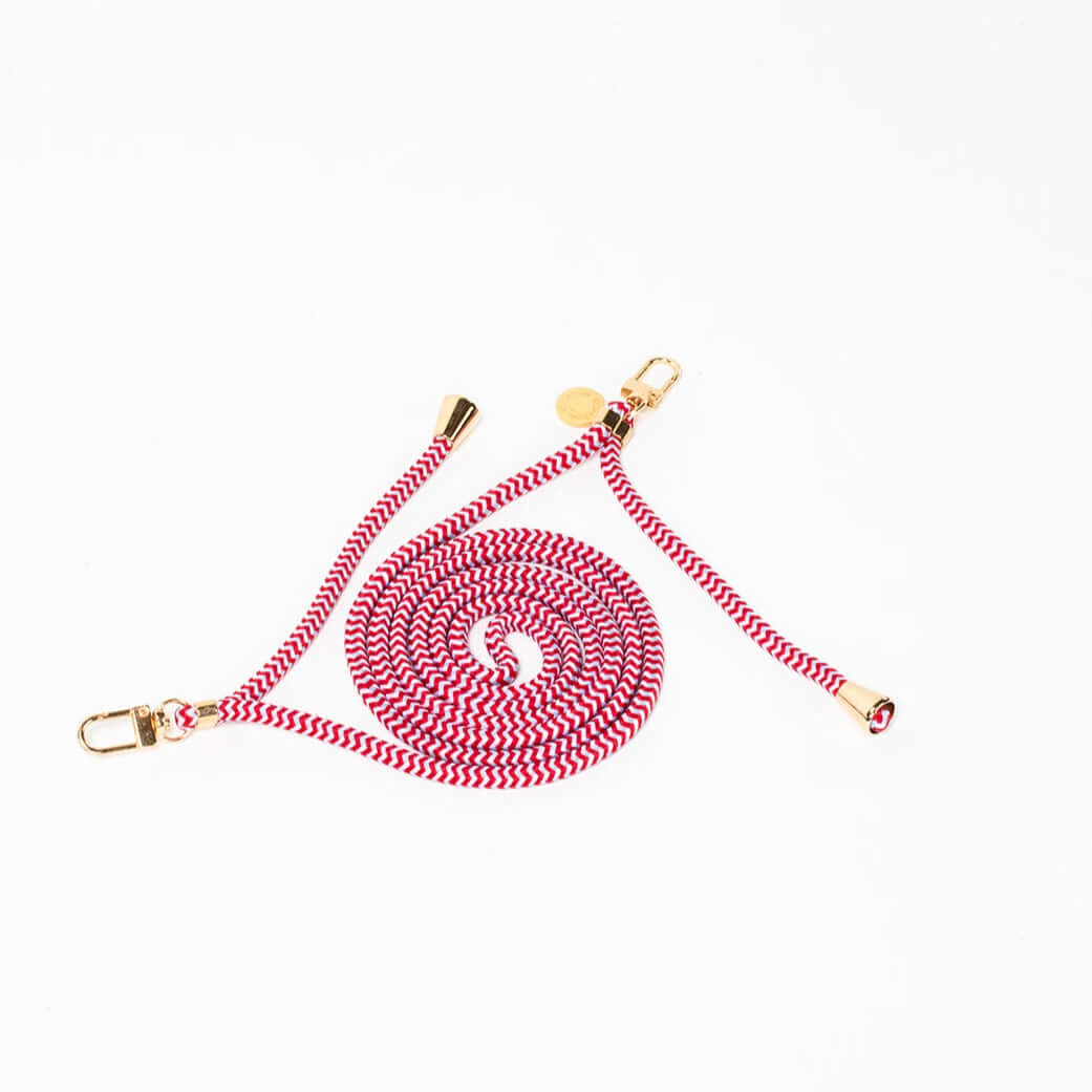 Red and white chevron-patterned Multi Colorful PHONE CORD coiled with gold-tone hardware on white.