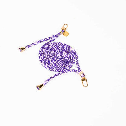 Purple and white chevron-patterned Multi Colorful PHONE CORD coiled with gold-tone hardware on white.